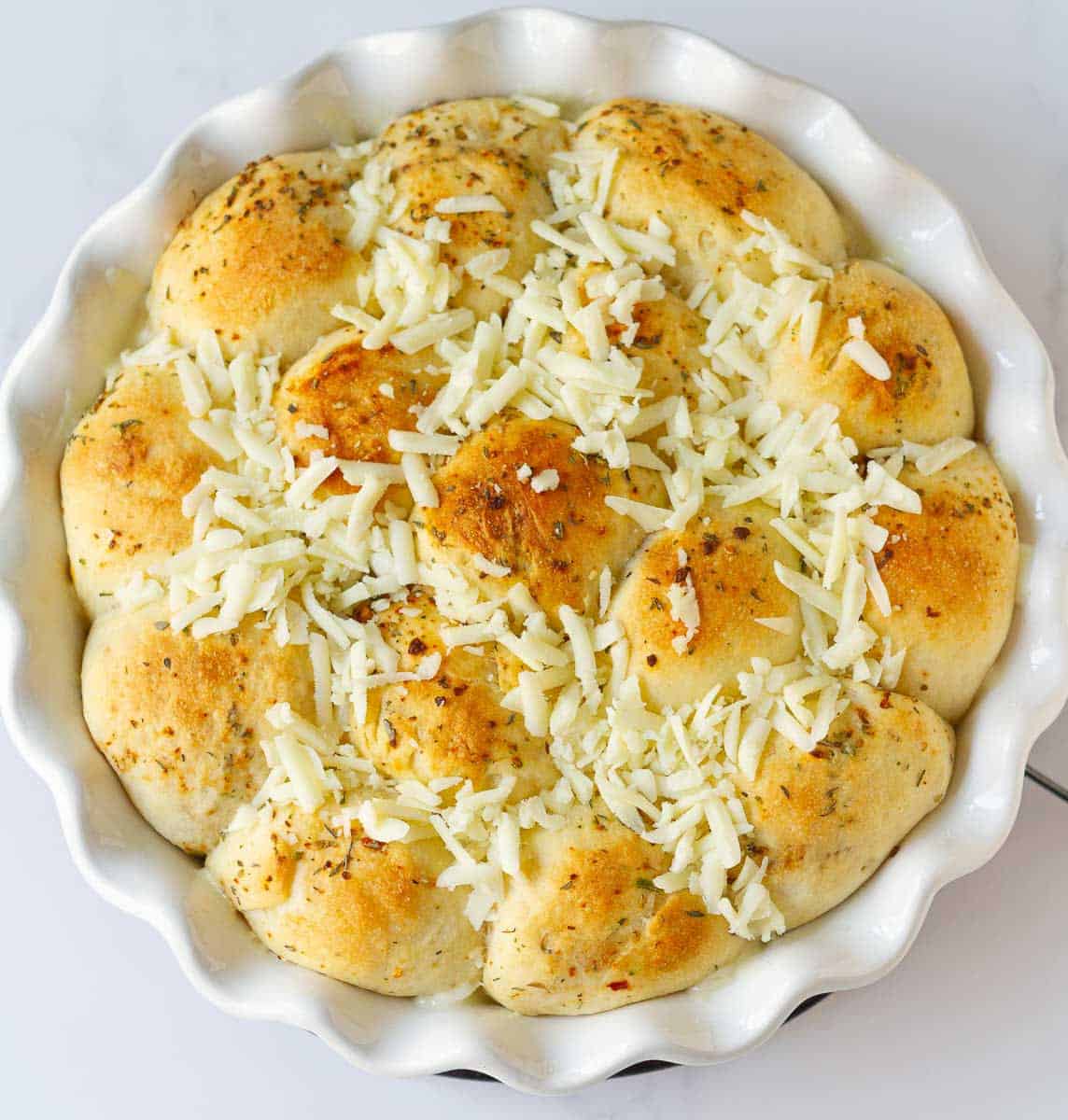 Grated cheese on top of the baked bread.