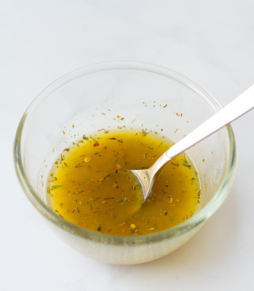 garlic herb butter in a bowl with a spoon.