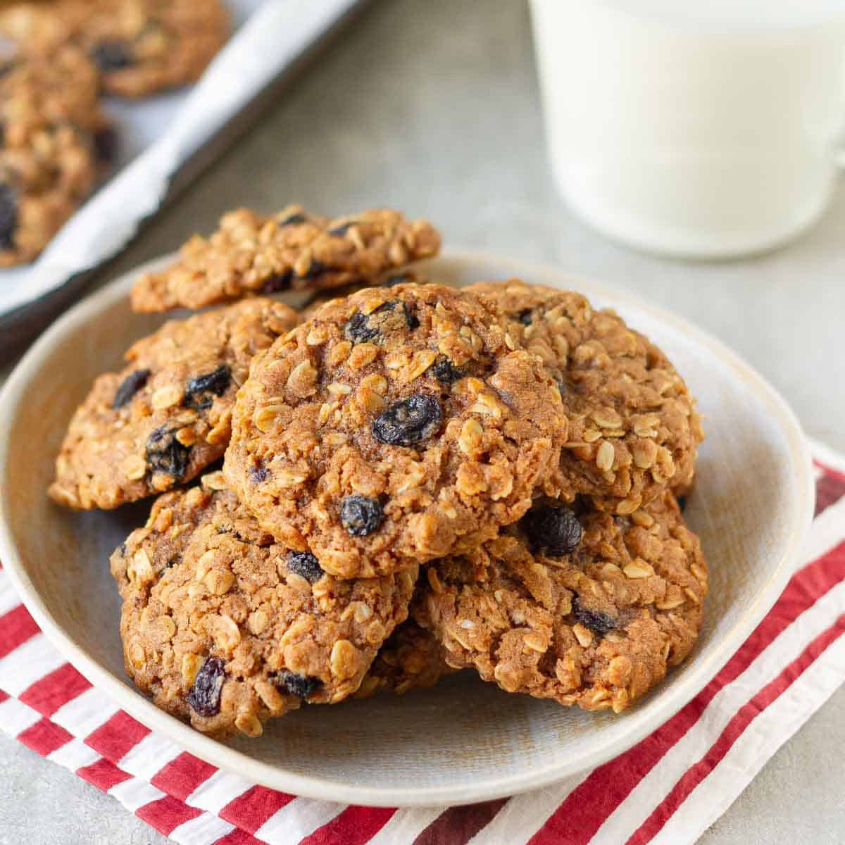 Oatmeal Raisin Cookies in a small plate on a red striped napkin.