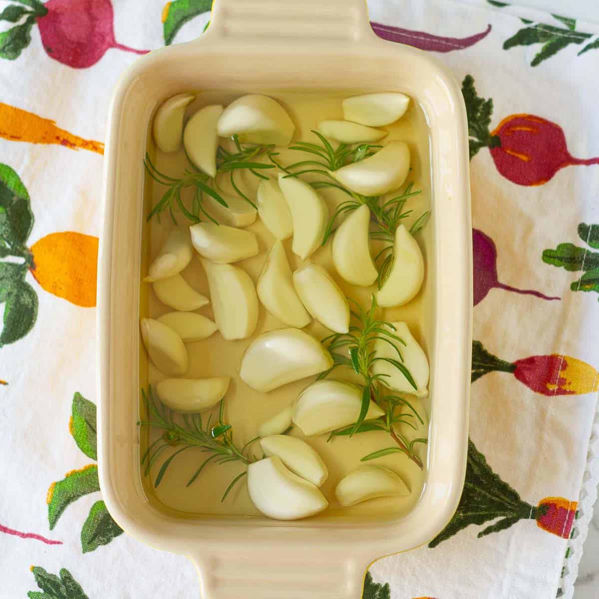 garlic cloves, rosemary and canola oil in a small baking dish