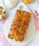 Mango Bread on a white board with ingredients on the side.