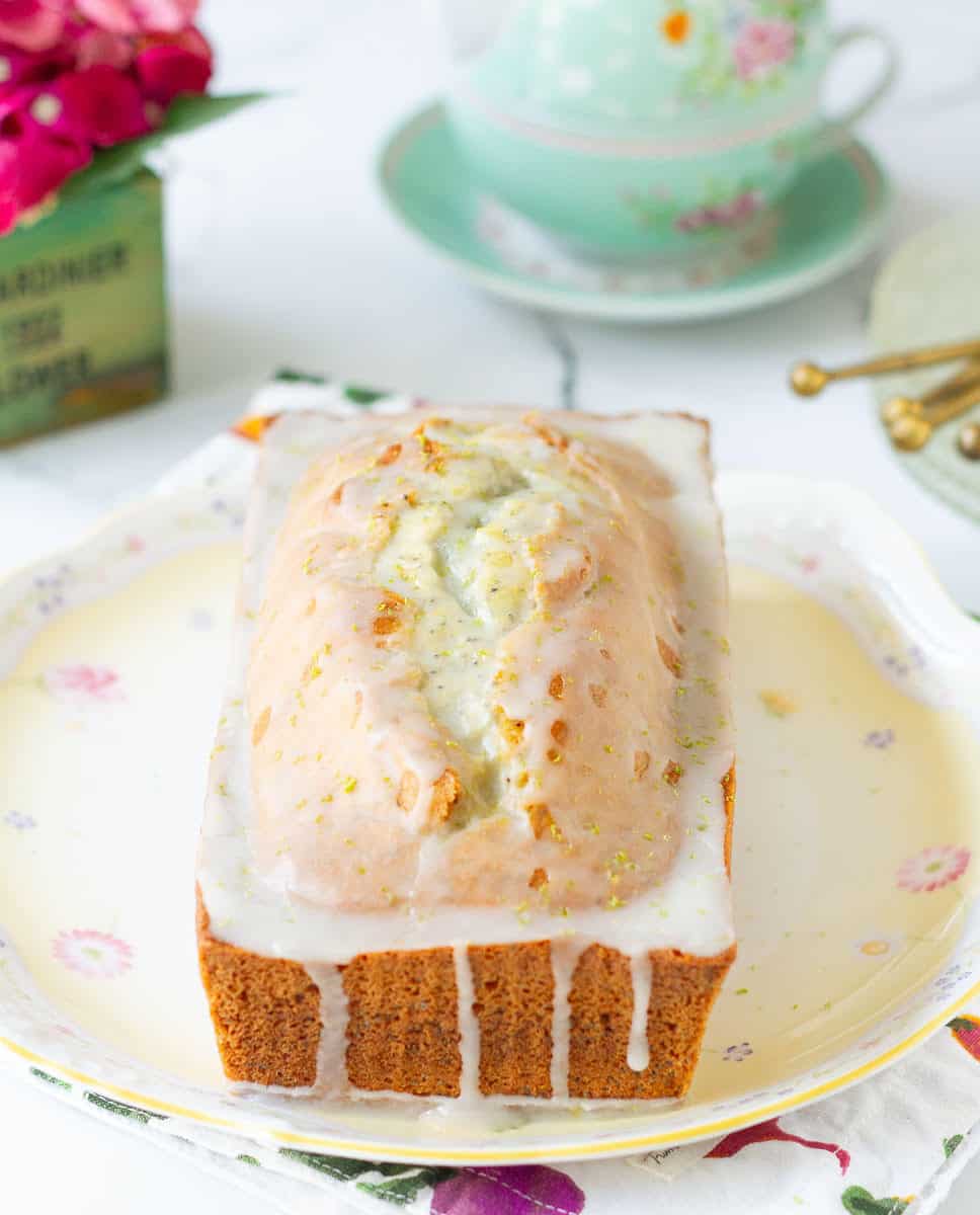 Lemon poppyseed bread with lemon glaze on a platter.