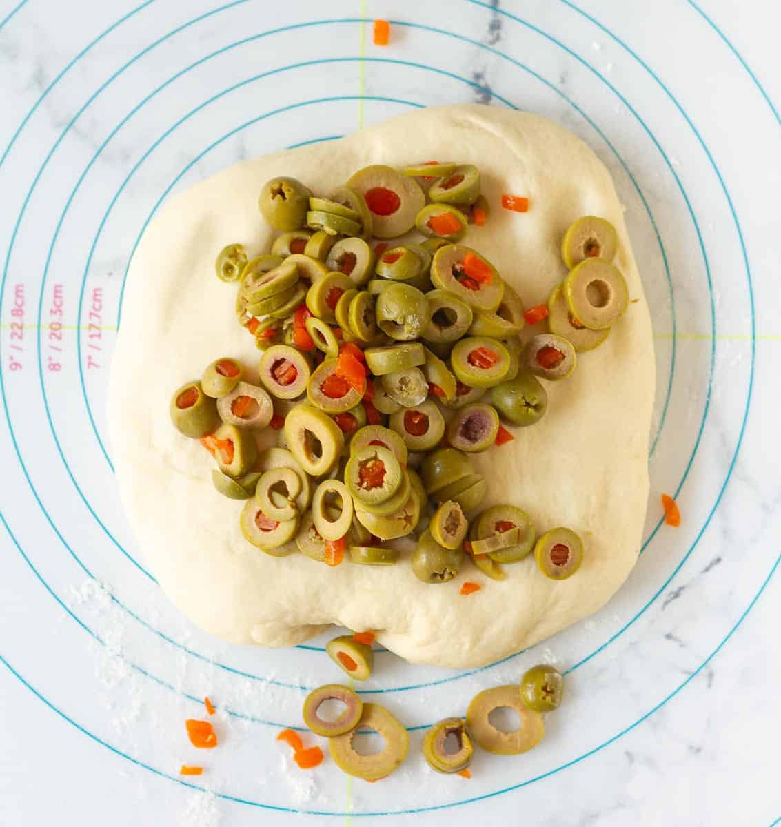 Olives on top of the dough for olive bread