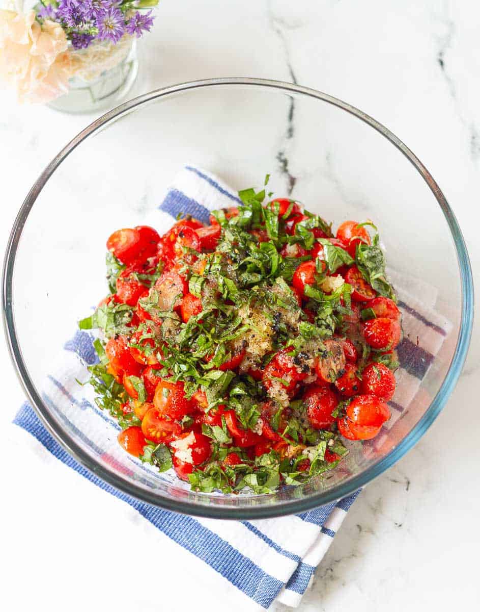 ingredients for marinated tomatoes in a mixing bowl.