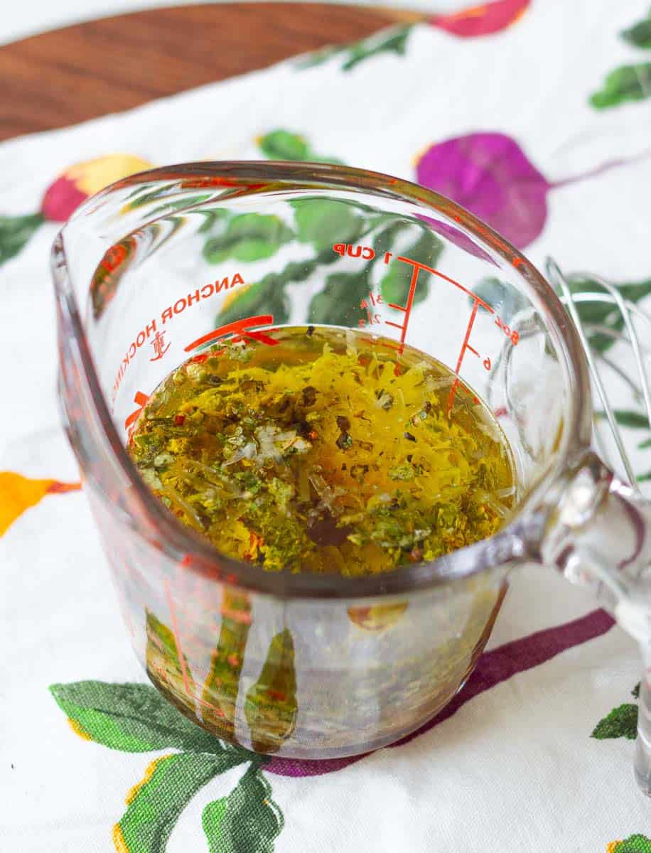 ingredients for the Italian salad dressing in a glass measuring cup