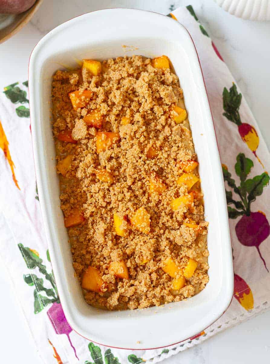 Batter for peach bread with struesel on top in a loaf pan.