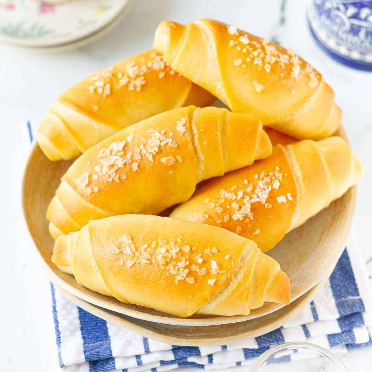 Bread rolls topped with sea salt in a bowl.