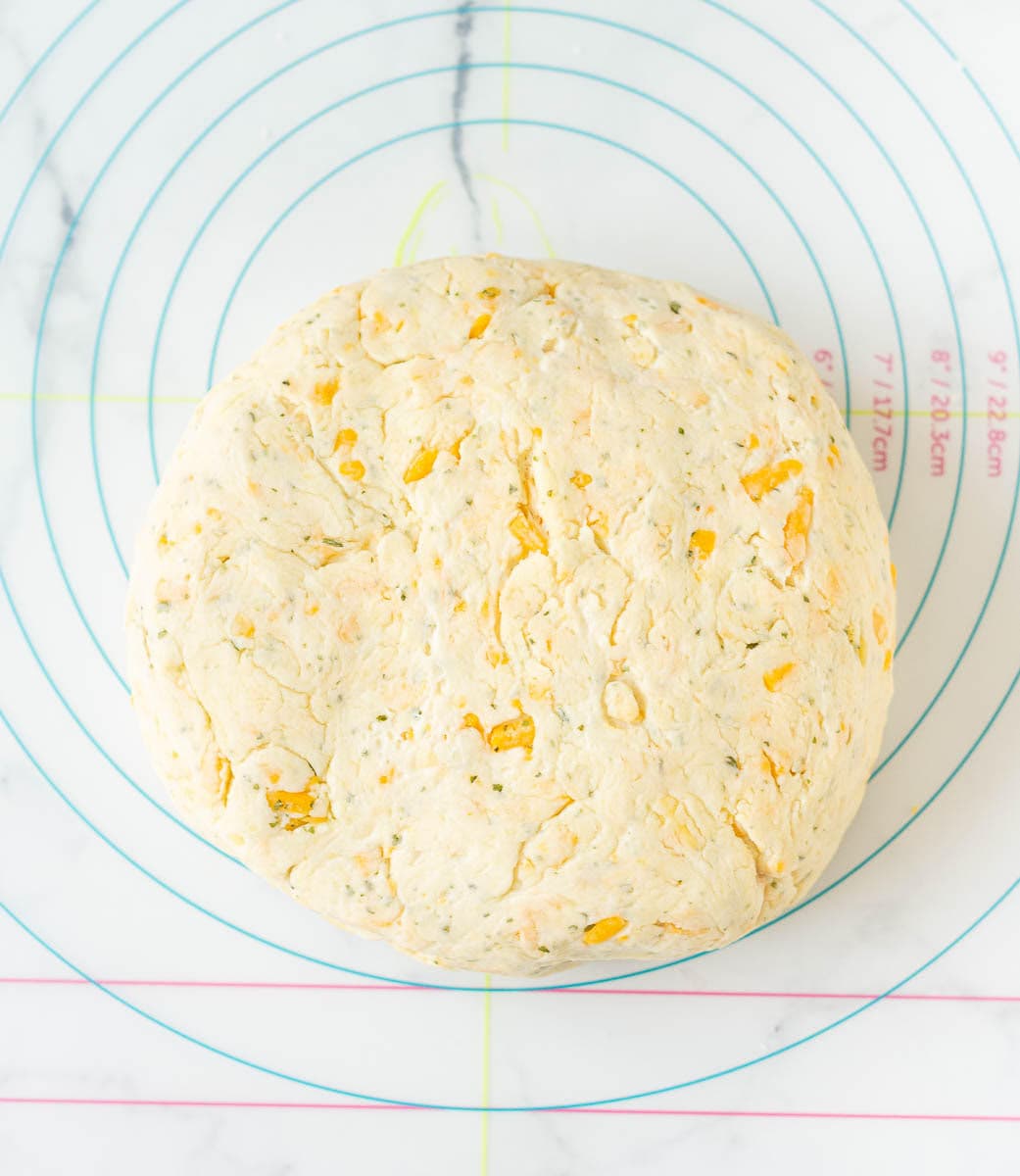Ready dough for making cheese scones on a silicon mat