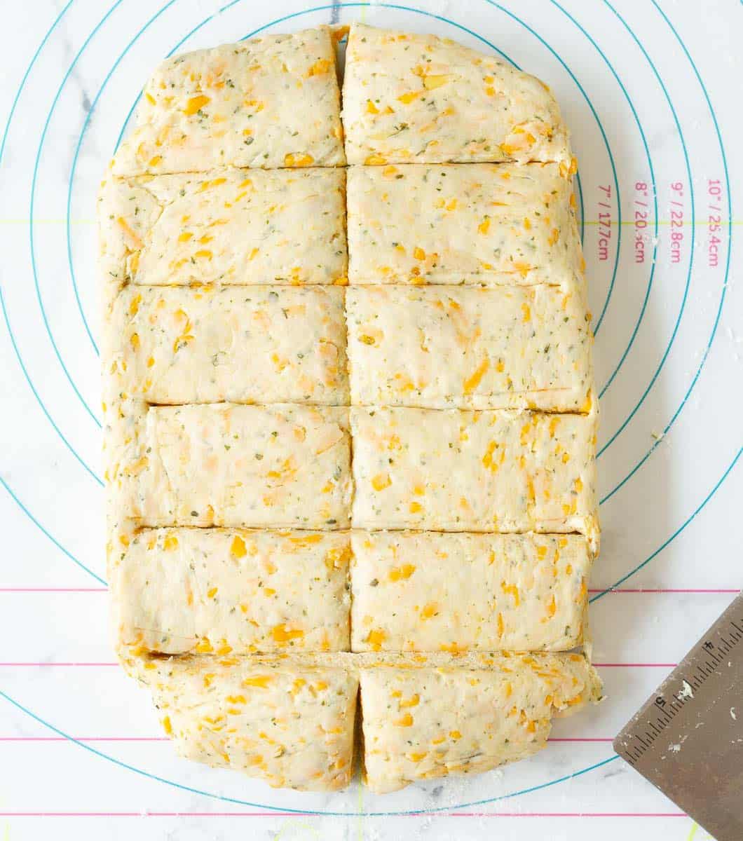Rolled out dough for cheese scones cut into 12 rectangles