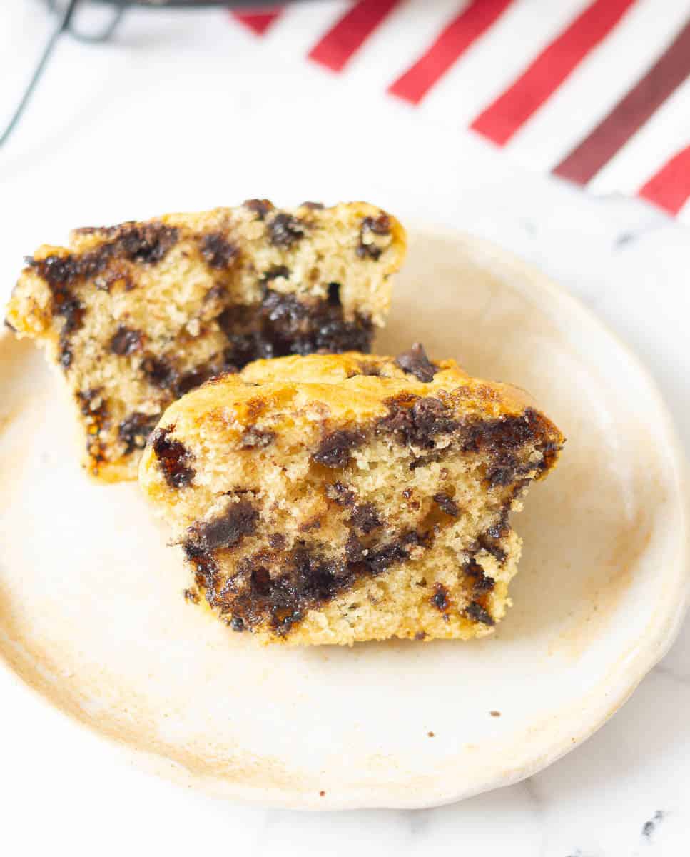 A muffin cut in half on a small plate.