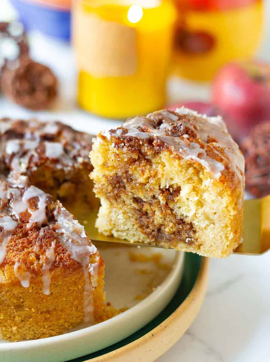A slice of apple cake on a cake server.