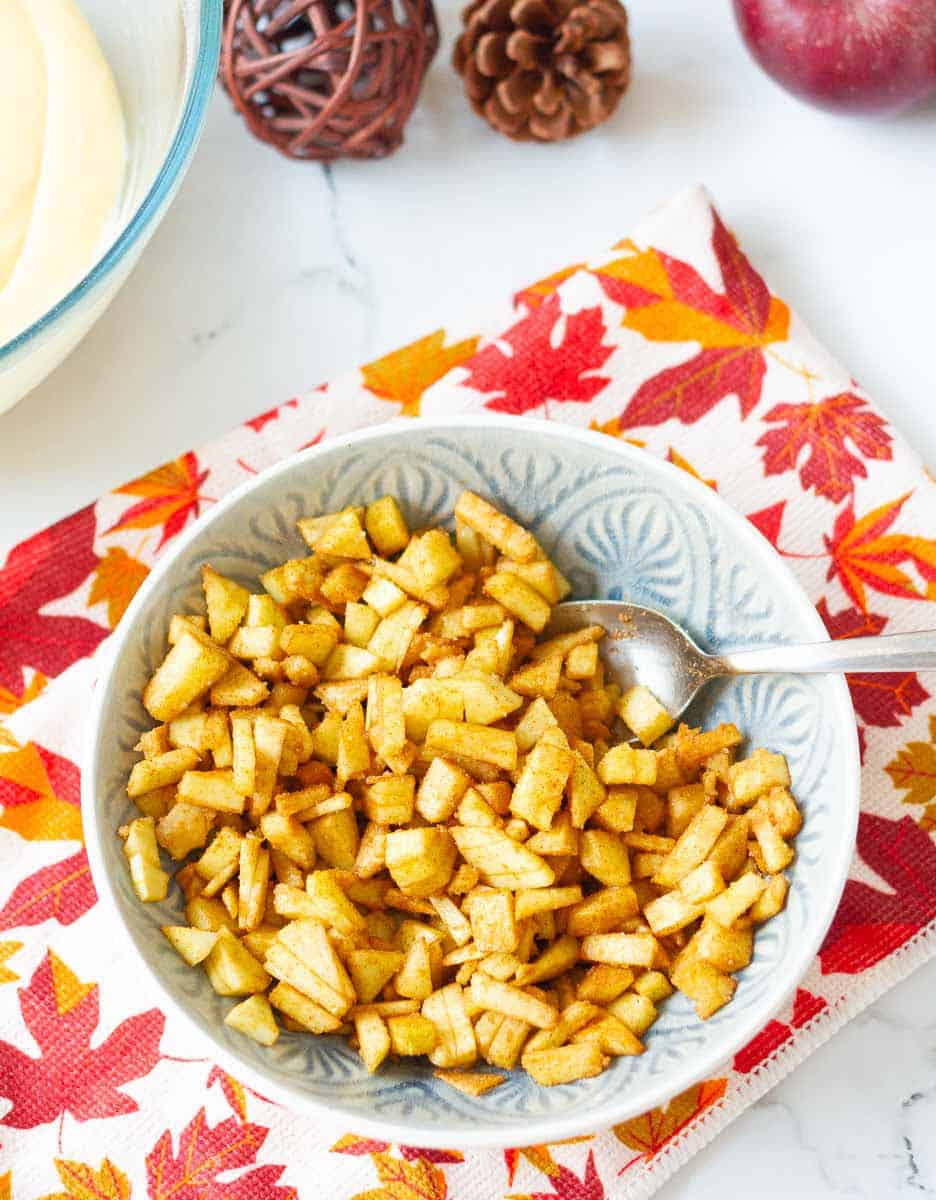 cinnamon mixed with apples for apple cake.
