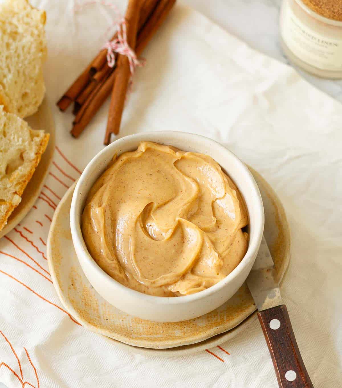 Cinnamon Honey Butter in a small bowl with a butter knife and ingredients in the background.