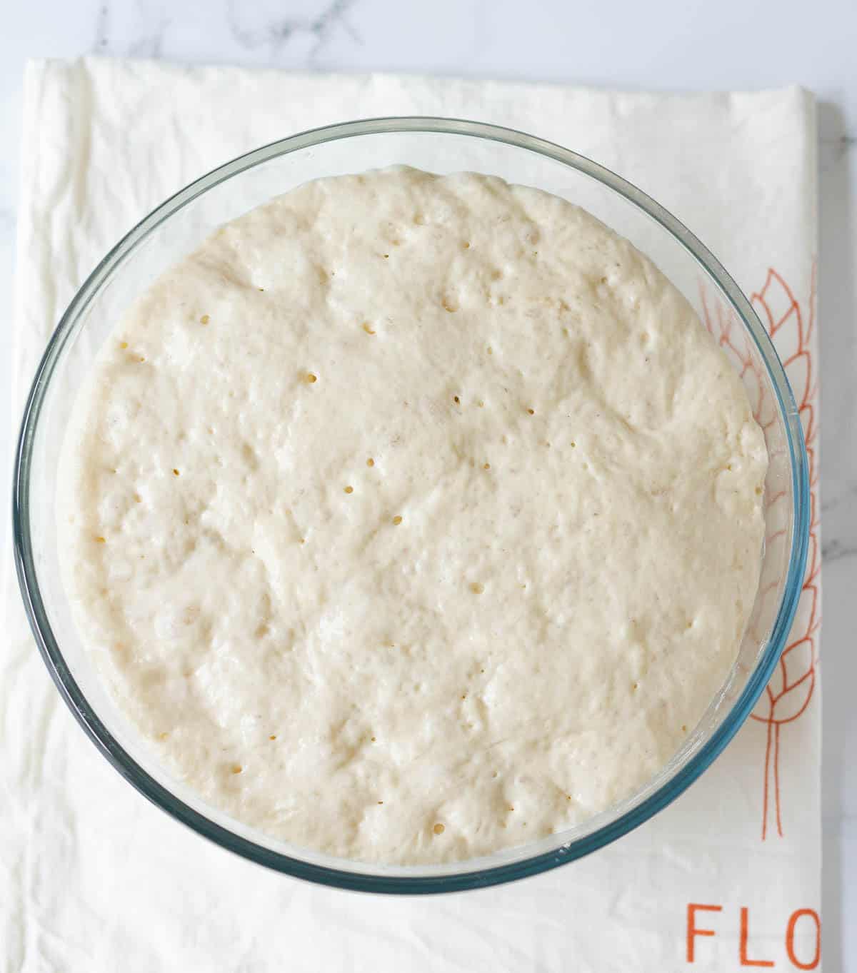 Proofed dough after 4 hours in a glass bowl.