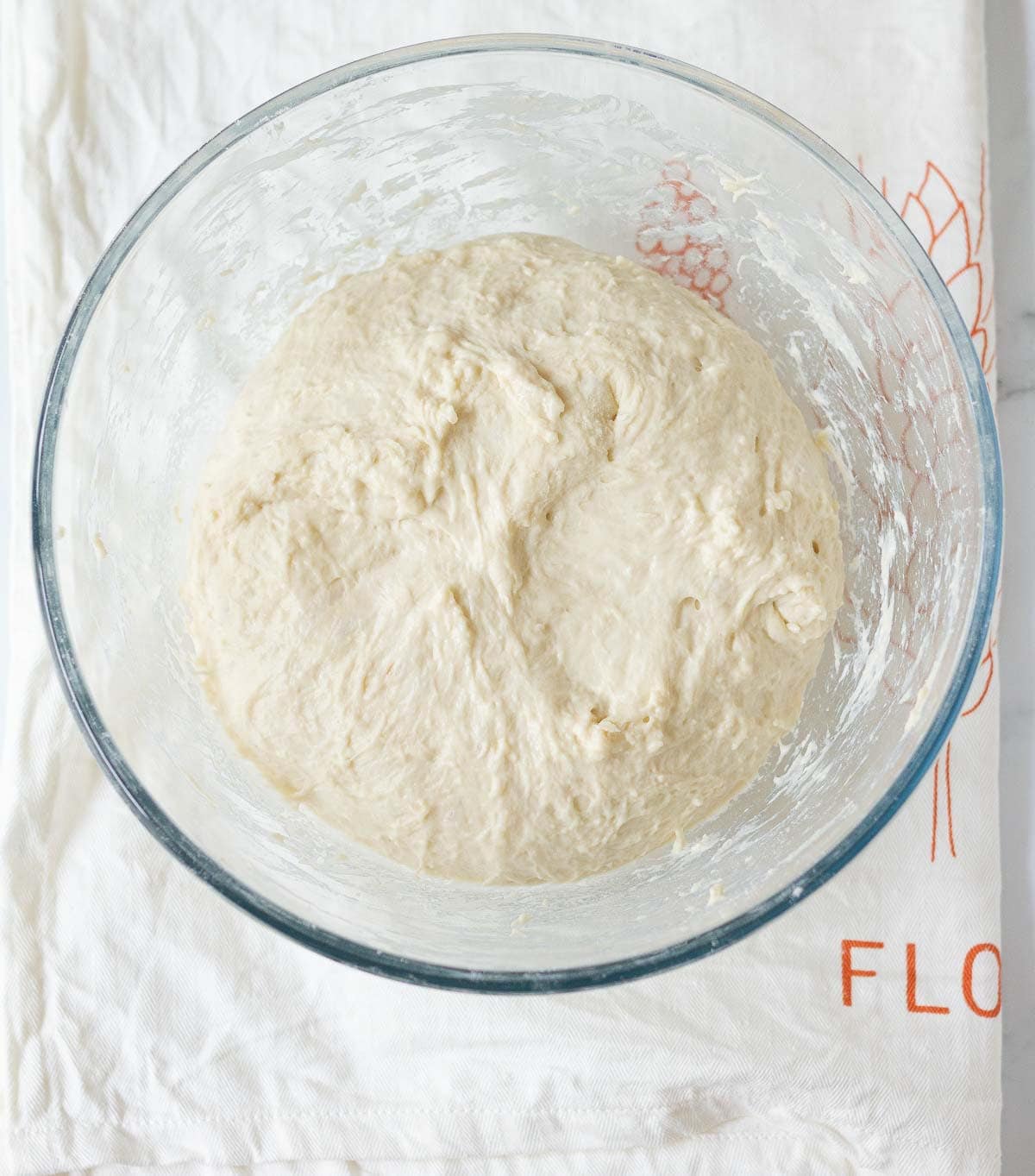 Bread dough in a glass bowl.