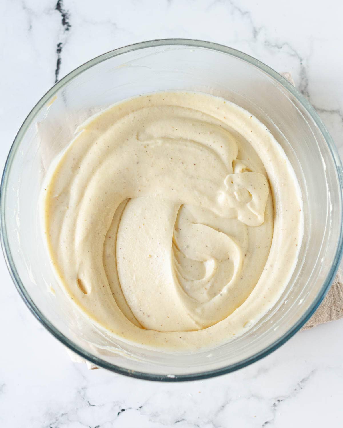 Whipped mascarpone cheese with chai flavors in a glass bowl.