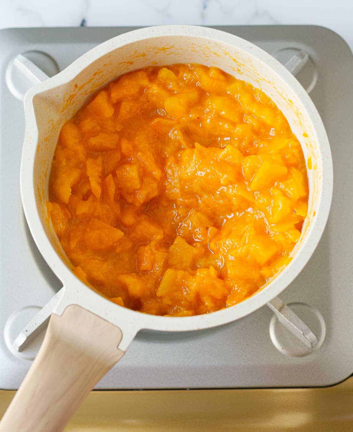 softened, cooked persimmons in a saucepan.