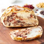 sliced no-knead cranberry walnut bread on a wooden board.