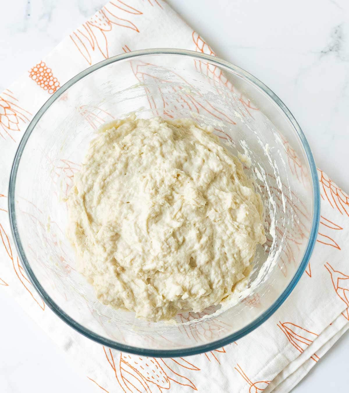 mixed bread ingredients in a glass mixing bowl.