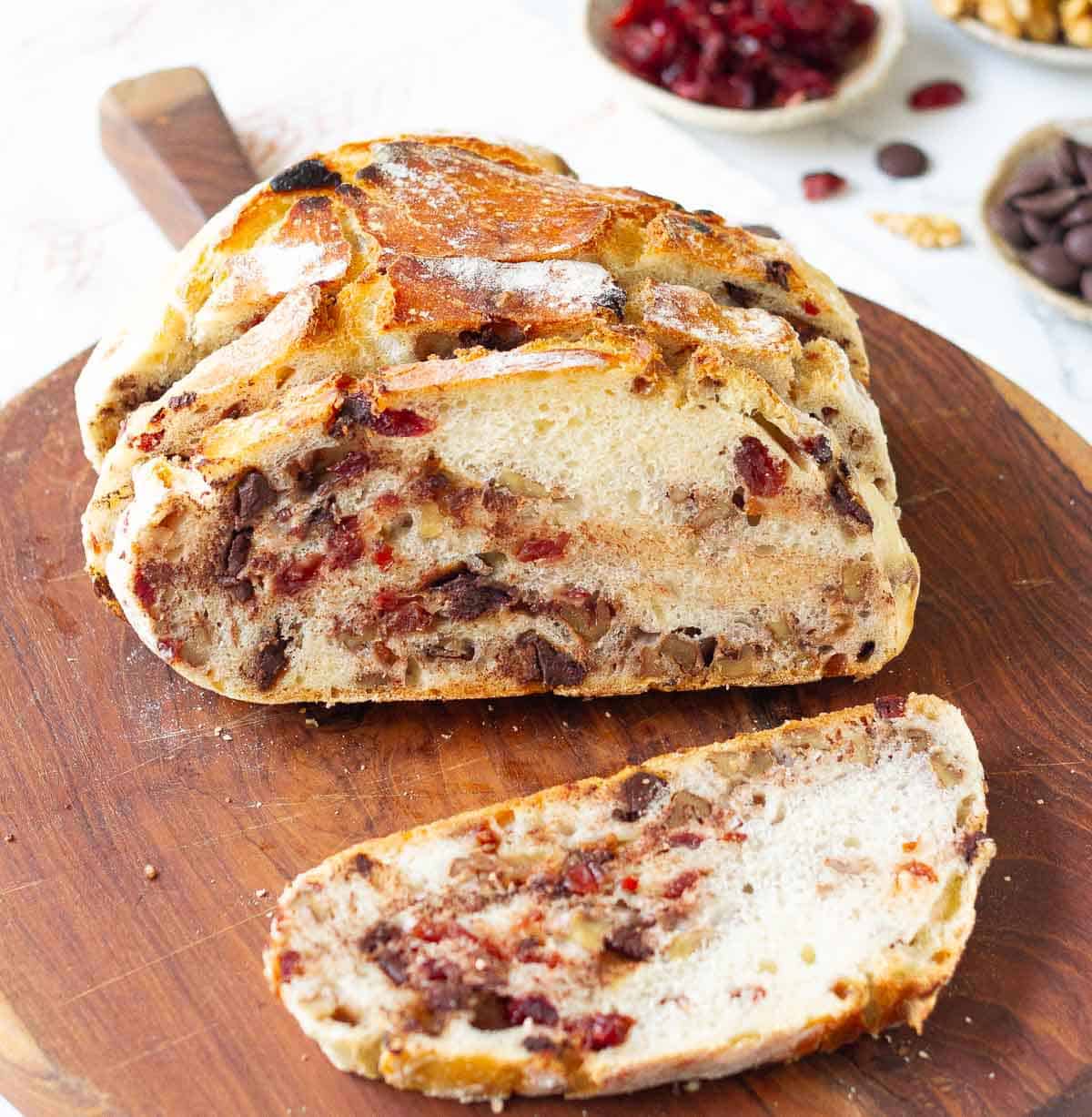 Sliced no-knead cranberry walnut bread on a wooden board.