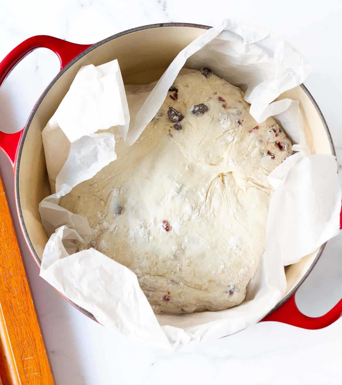 bread dough on a parchment paper in a Dutch oven.