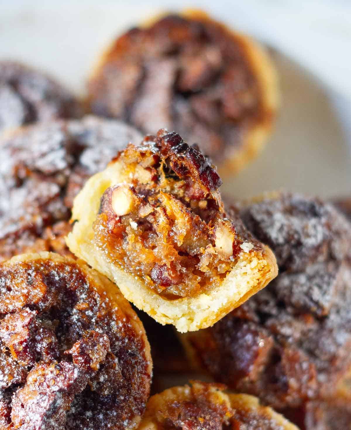 half of a pecan tassie to show the gooey filling.