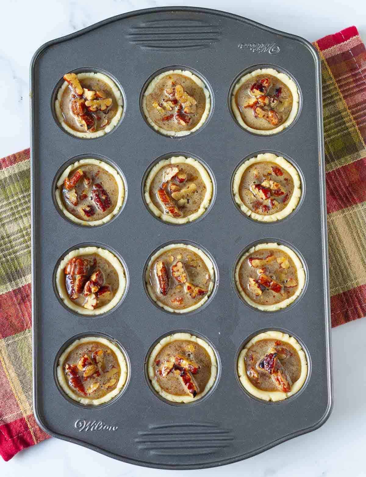 pie filling in tart cases in a mini muffin pan.