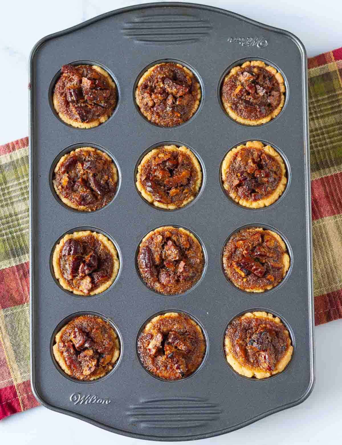baked mini pecan pies in mini muffin pan.