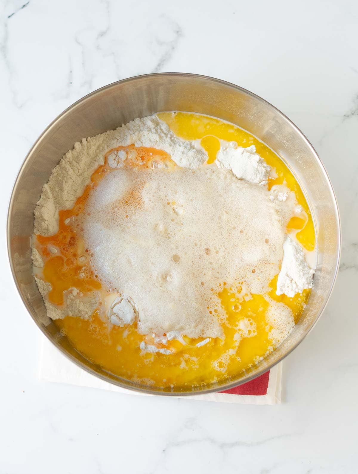 dry and wet ingredients for the bread in a metal mixing bowl.