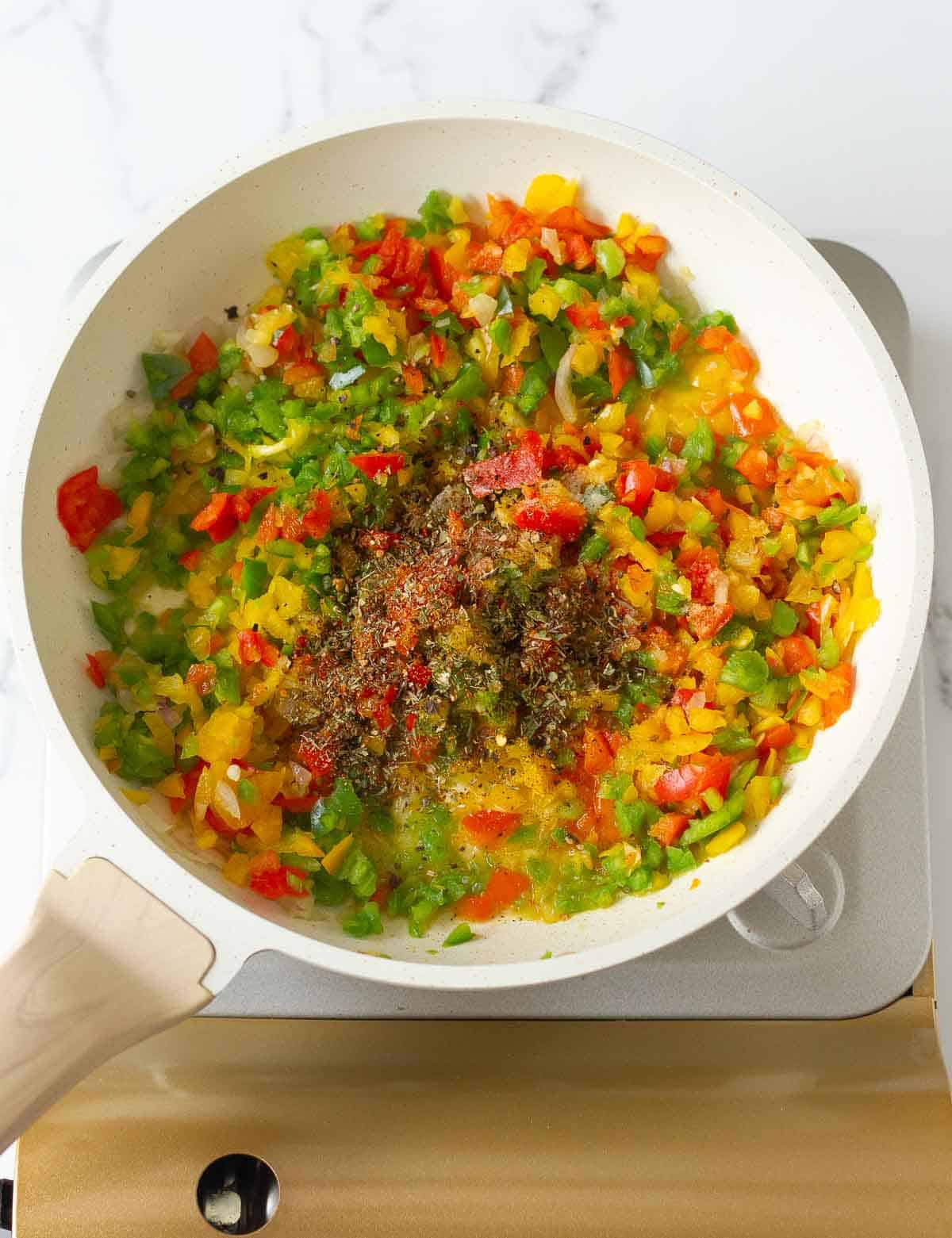 sauteed veggies in a saucepan with seasoning on top.
