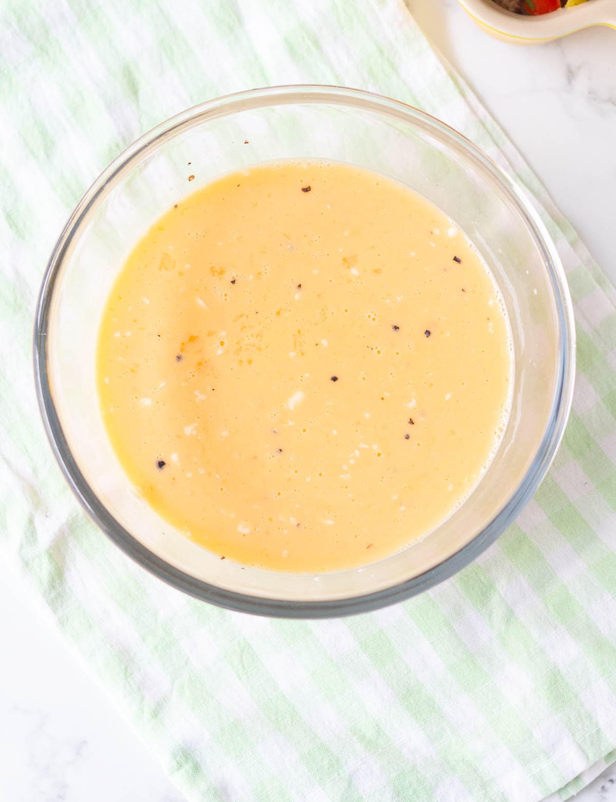 mixture of eggs, milk, and cheese in a mixing bowl.