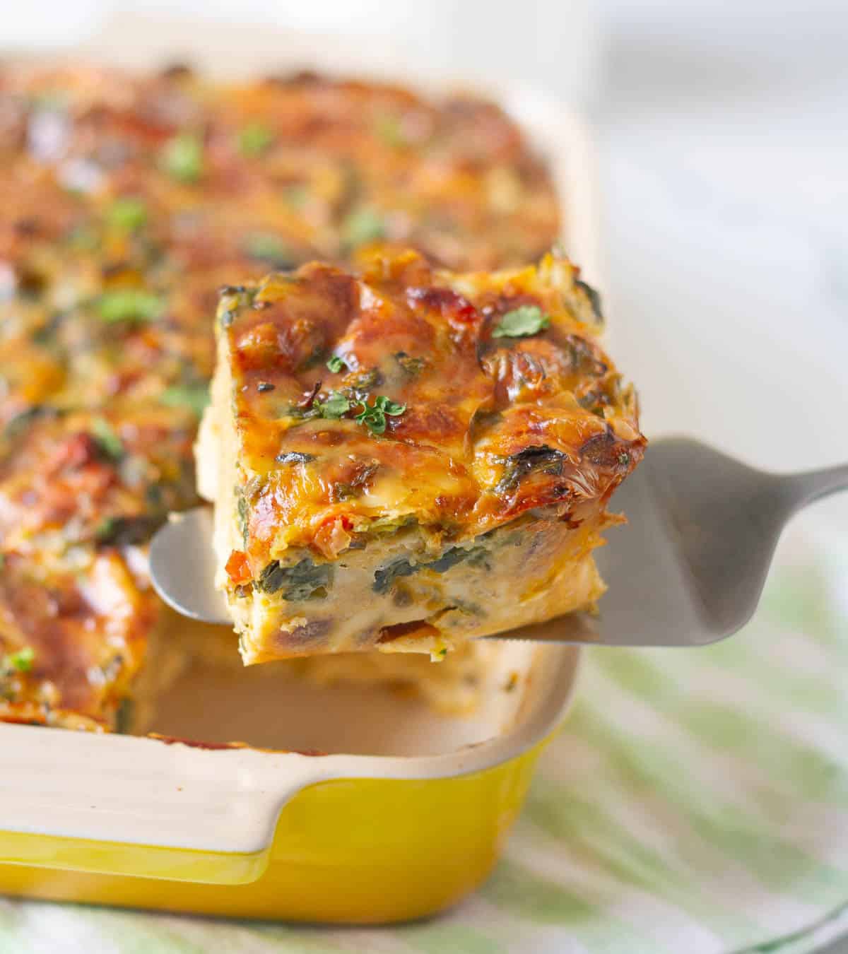 a slice of breakfast casserole on a pie server.