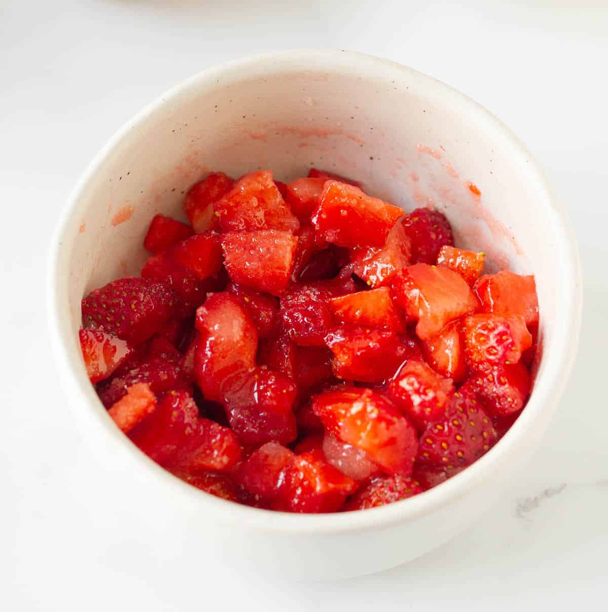 Chopped strawberries and sugar in a small bowl.
