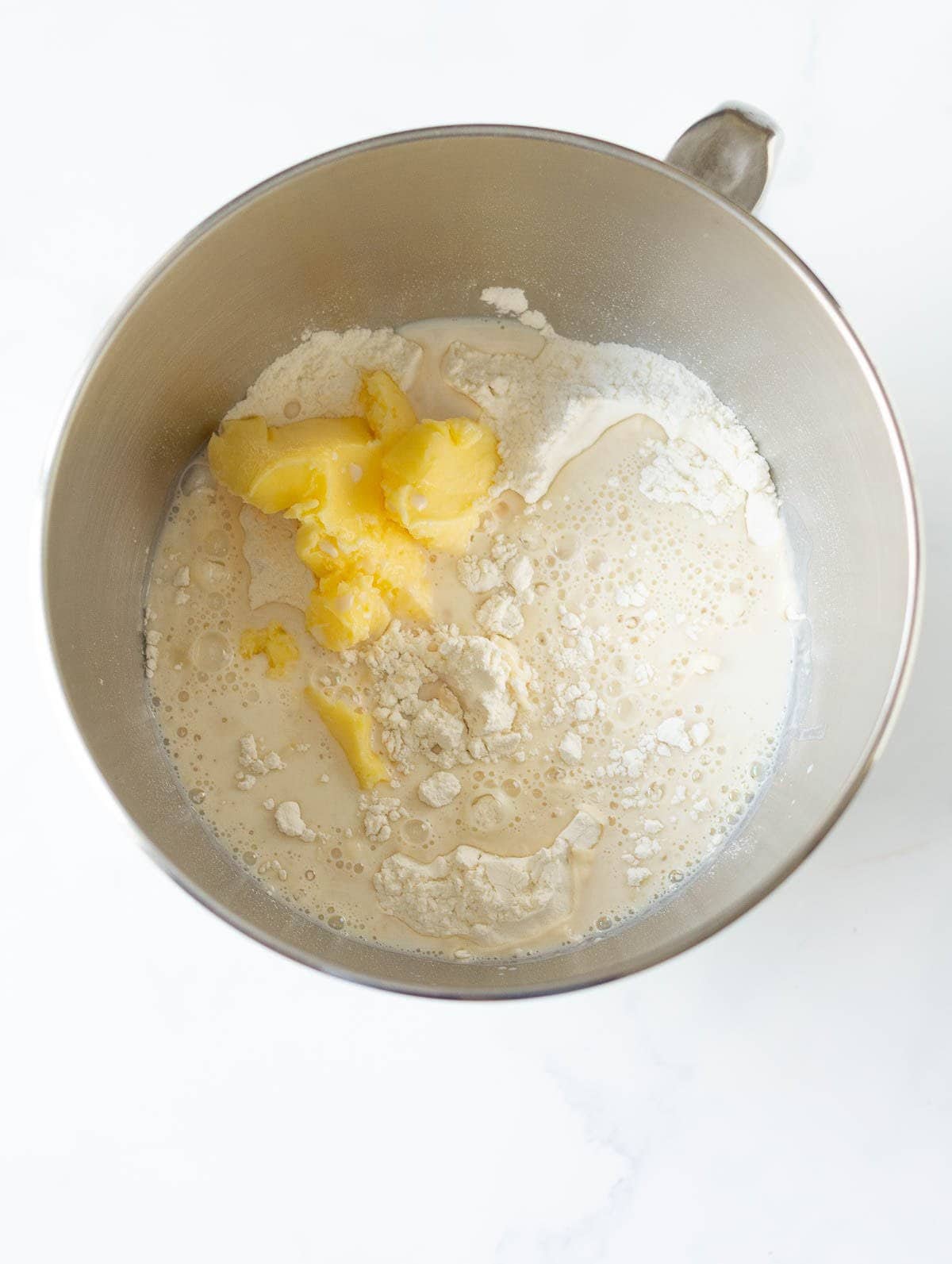water-yeast mixture, flour, and butter in a stand mixer bowl.