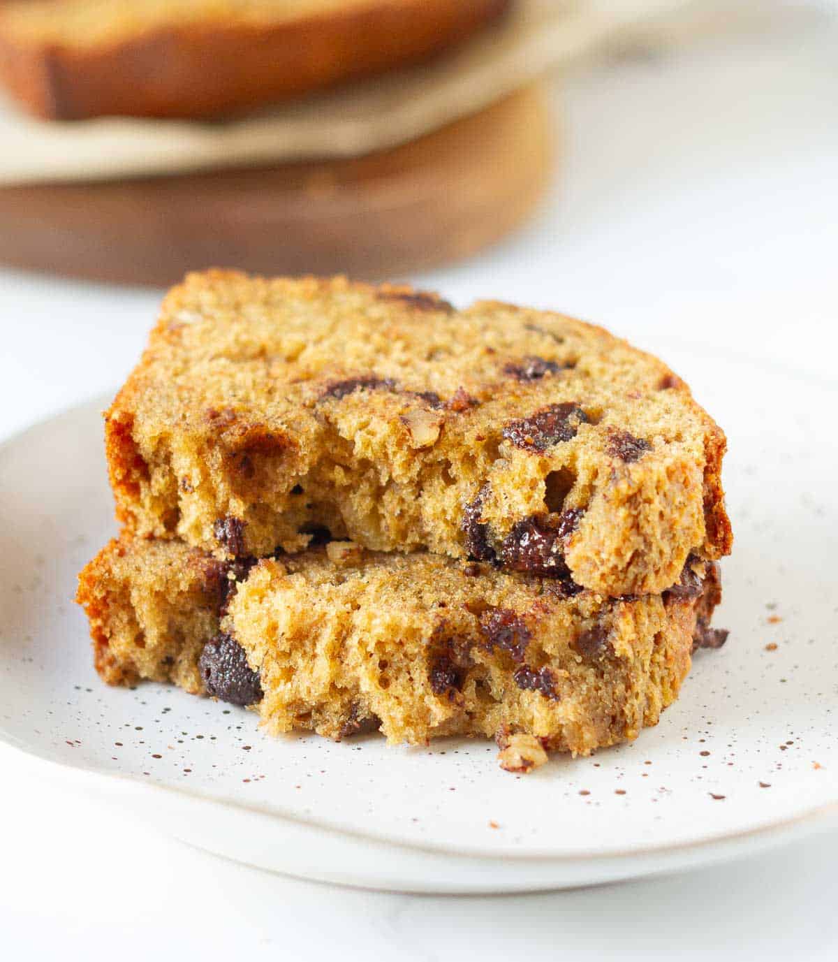 2 halves of a slice of banana bread stacked on a plate.