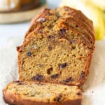 sliced sourdough banana bread with ingredients in the background.