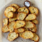 Toasted bread slices on a piece of parchment paper.