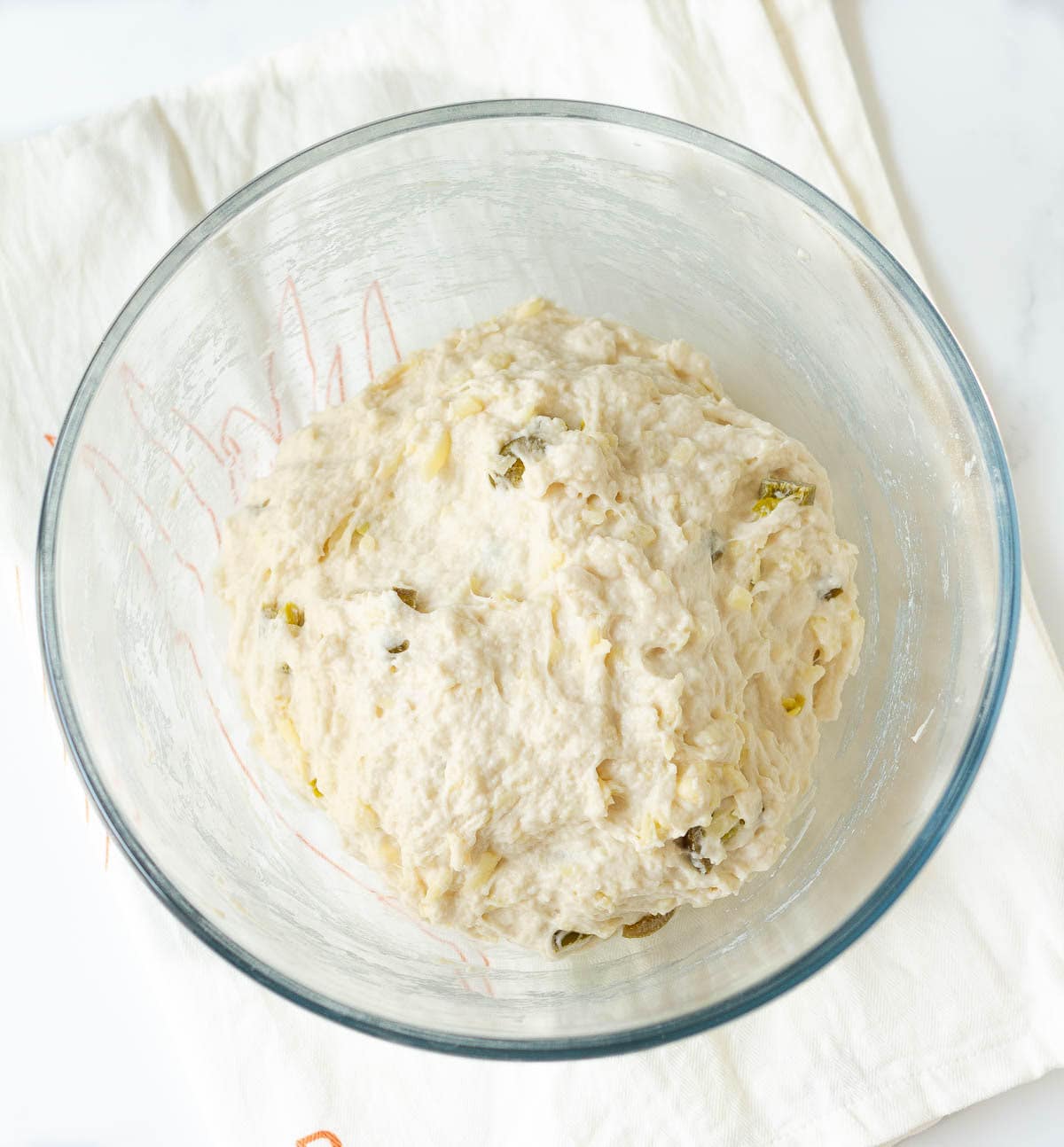 A roughly mixed bread dough in a mixing bowl.