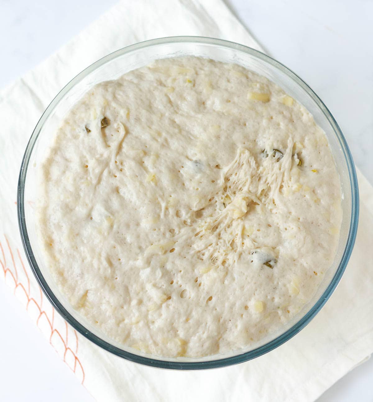 Proofed bread dough in a mixing bowl.