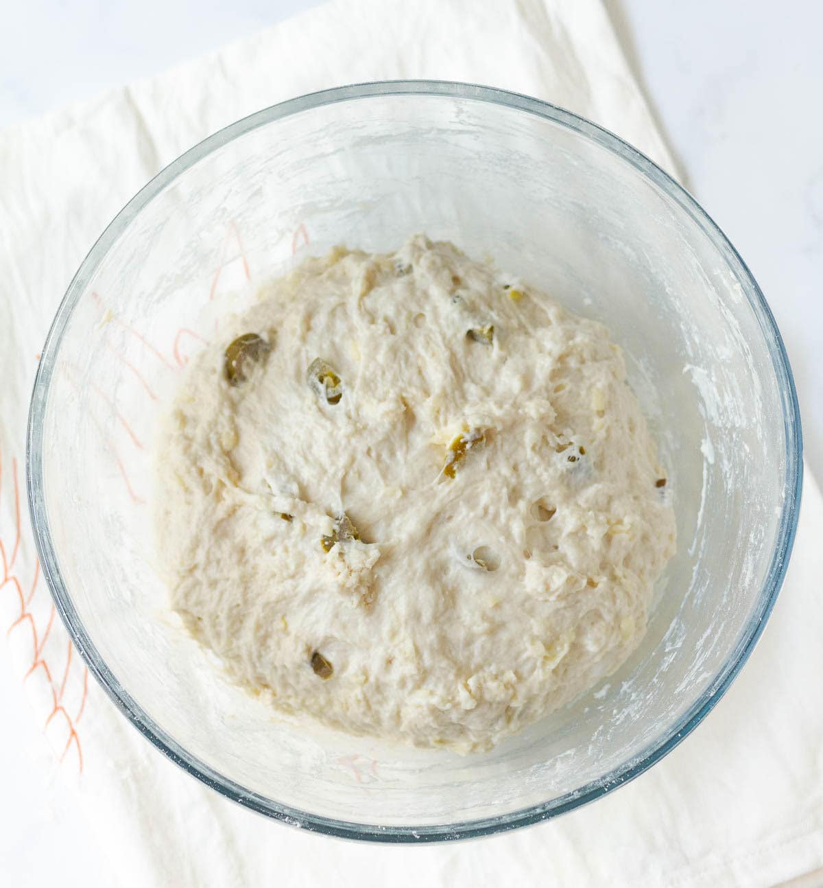 Bread dough in a glass bowl.