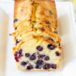 Sliced lemon blueberry bread on a white platter.