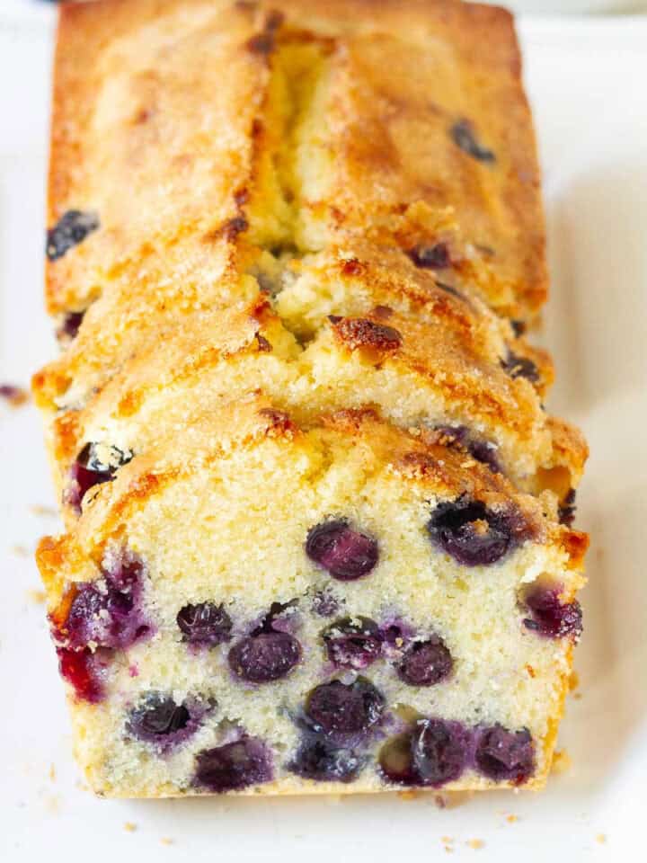 Sliced lemon blueberry bread on a white platter.