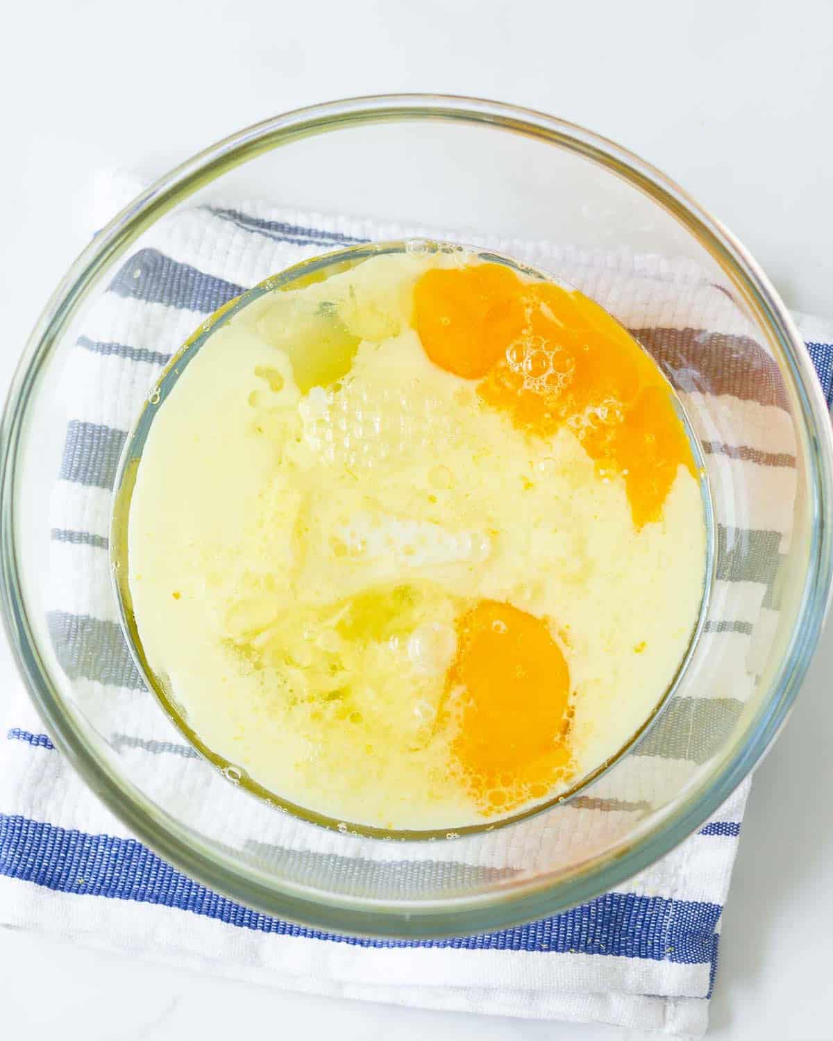 Eggs, milk, oil, lemon juice, and sugar in a mixing bowl.