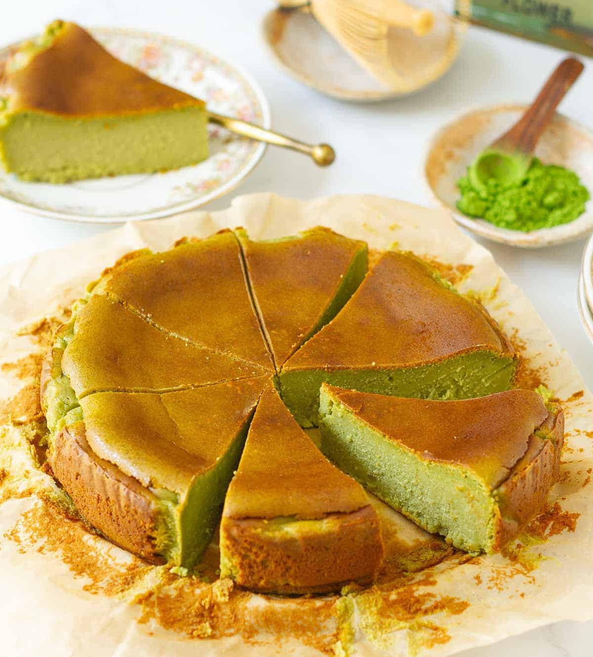 Sliced matcha cheesecake on parchment paper.