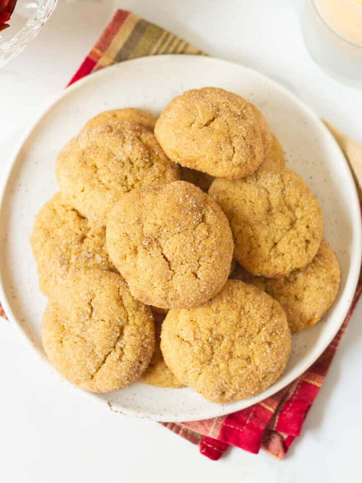 pumpkin snickerdoodle cookies stacked up on a plate.