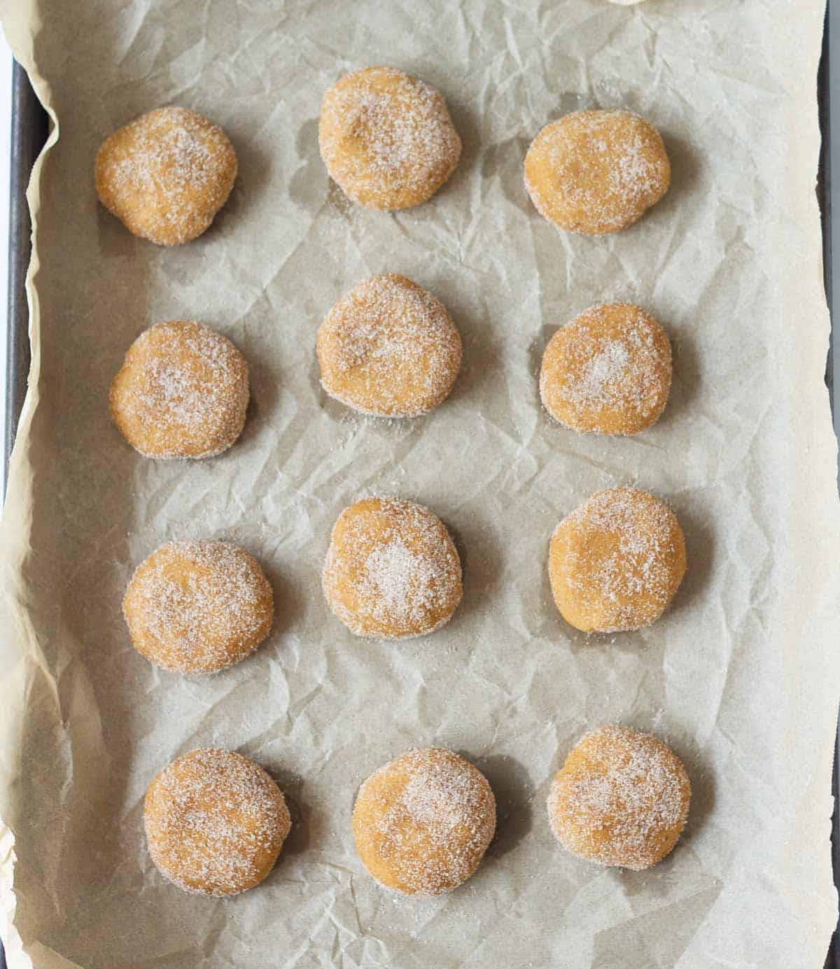 Cookie dough balls on a parchment-lined tray.