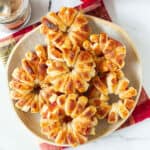 Puff pastry apple donuts stacked on a serving plate.
