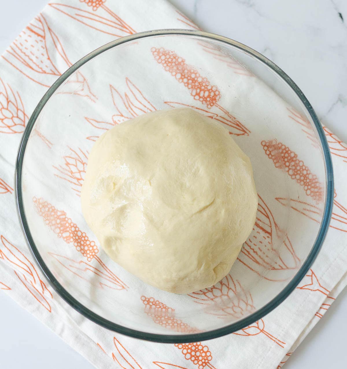 Kneaded bread dough in a mixing bowl.