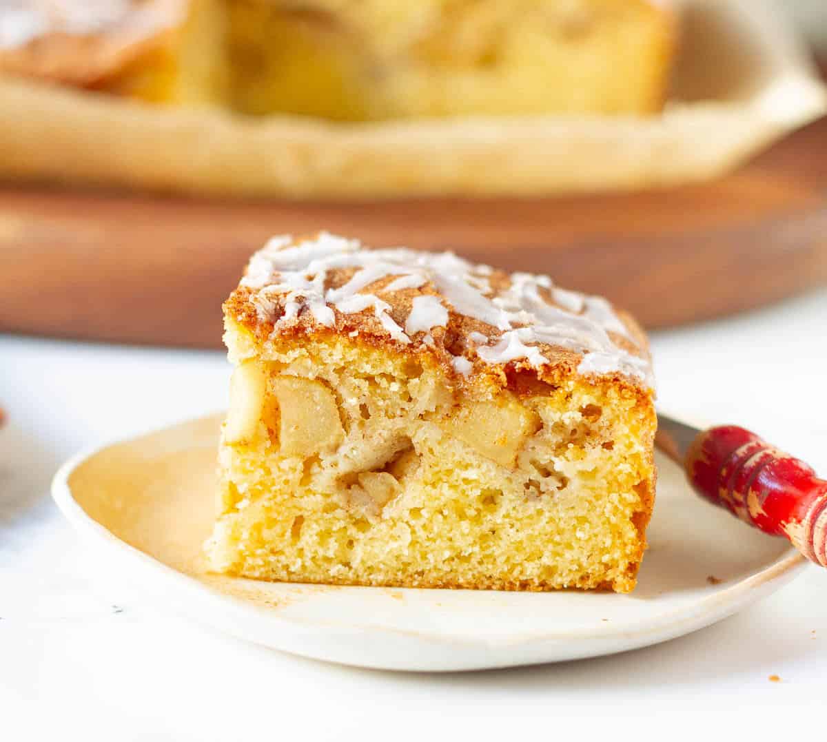 A slice of apple fritter cake on a small plate.
