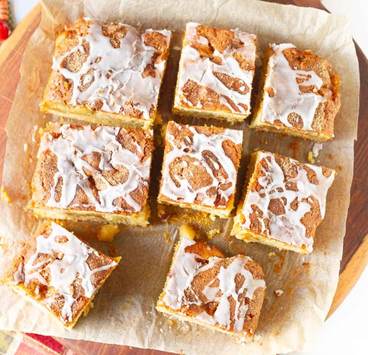 Squares of apple cake on parchment paper.